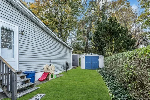 a view of a backyard with small cabin and a chair
