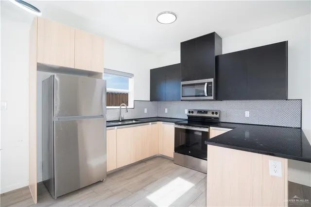 a kitchen with granite countertop a refrigerator and a stove