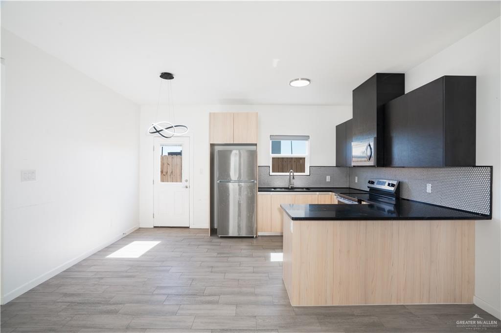 12509 North 40th Street, Unit 4 Edinburg, TX 78541 - Photo 16 of 27 a large kitchen with a refrigerator and a sink