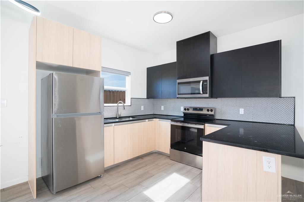 12509 North 40th Street, Unit 4 Edinburg, TX 78541 - Photo 17 of 27 a kitchen with granite countertop a refrigerator and a stove