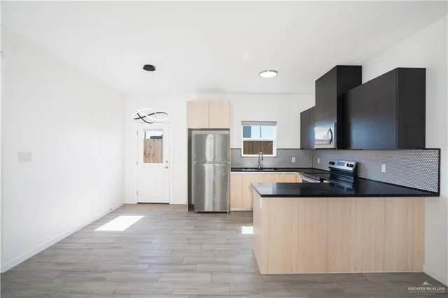 a large kitchen with a refrigerator and a sink