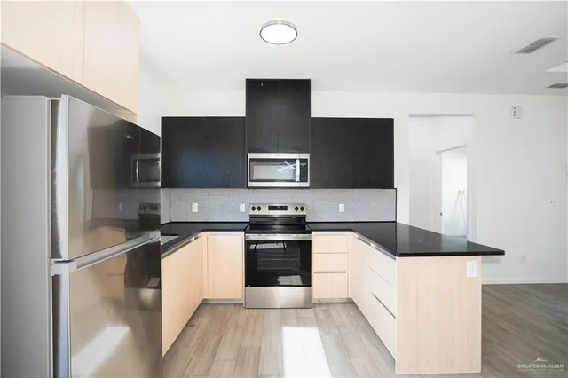 a kitchen with stainless steel appliances granite countertop a refrigerator and a stove