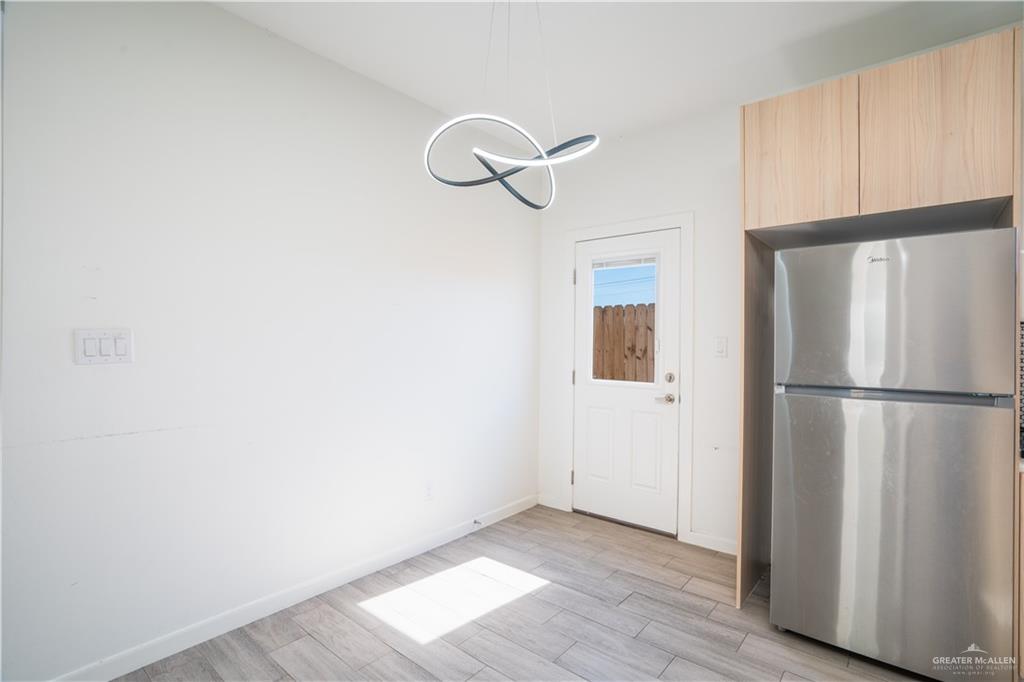 12509 North 40th Street, Unit 4 Edinburg, TX 78541 - Photo 6 of 27 a view of a refrigerator in kitchen and wooden floor