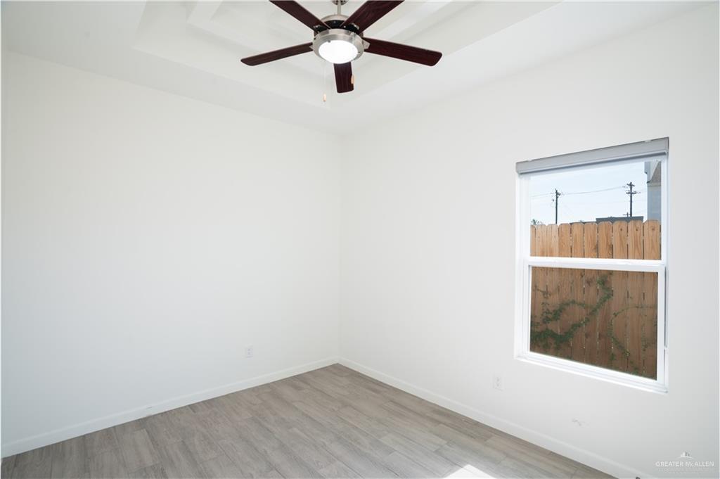 12509 North 40th Street, Unit 4 Edinburg, TX 78541 - Photo 10 of 27 a view of an empty room with wooden floor and a window
