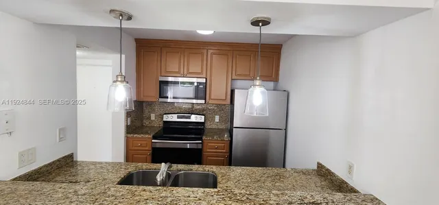 a kitchen with a refrigerator and a sink