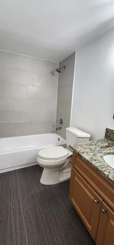 a bathroom with a granite countertop toilet a sink and bathtub