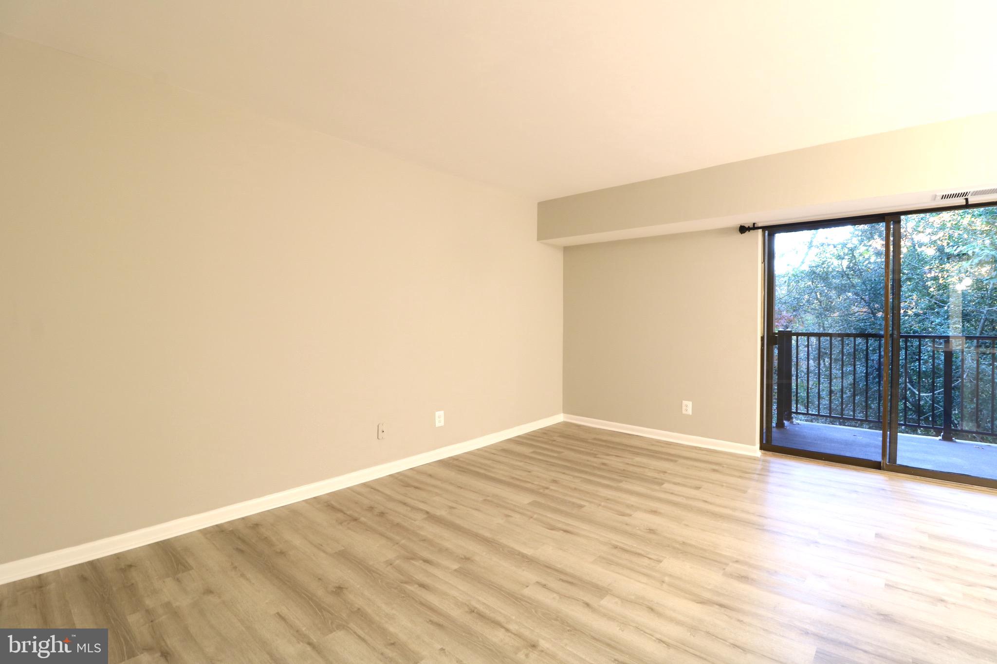 2249 Castle Rock Square, Unit 11C Reston, VA 20191 - Photo 14 of 26 a view of an empty room with wooden floor and a window
