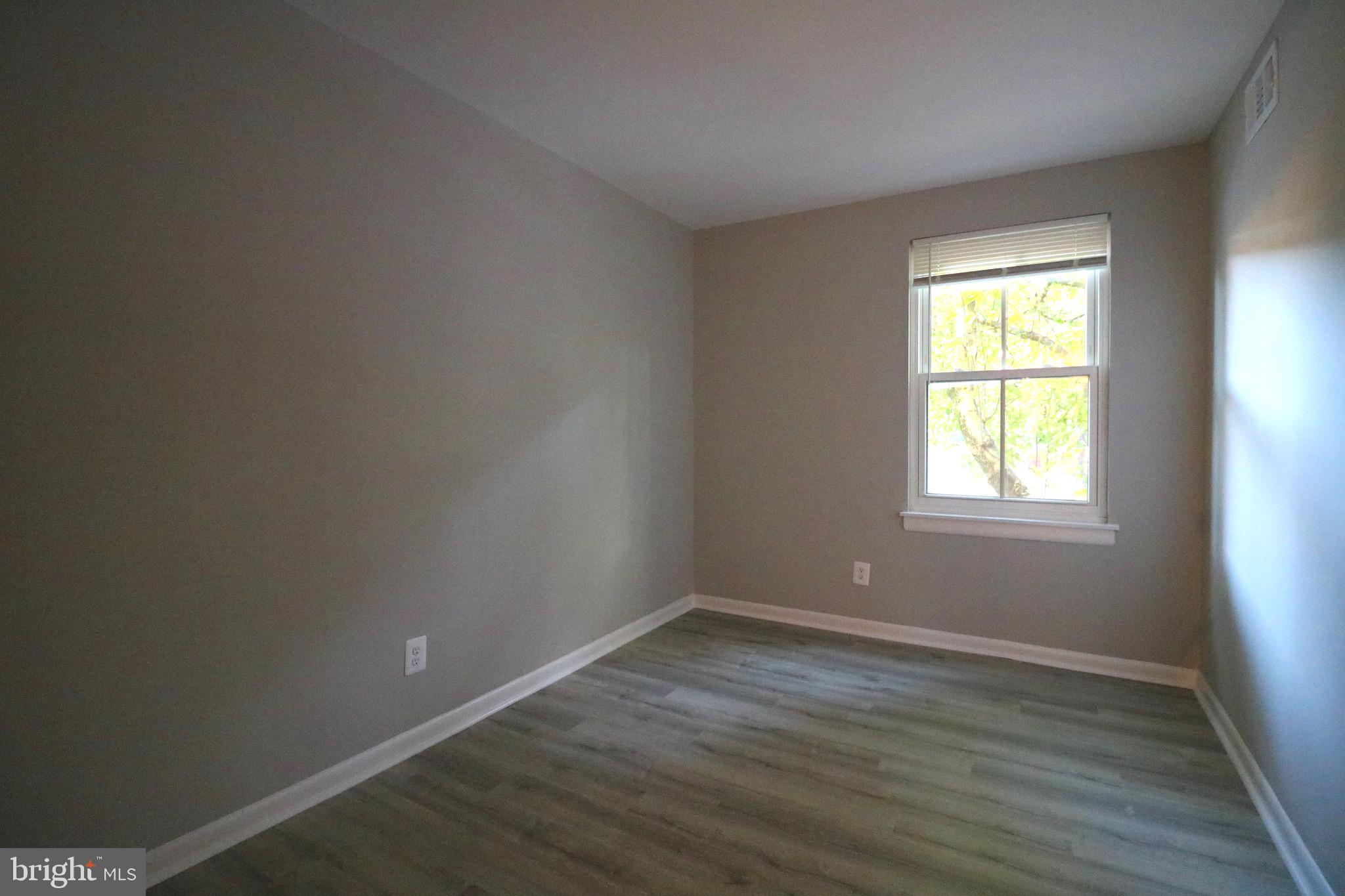 2249 Castle Rock Square, Unit 11C Reston, VA 20191 - Photo 15 of 26 a view of an empty room with wooden floor and a window