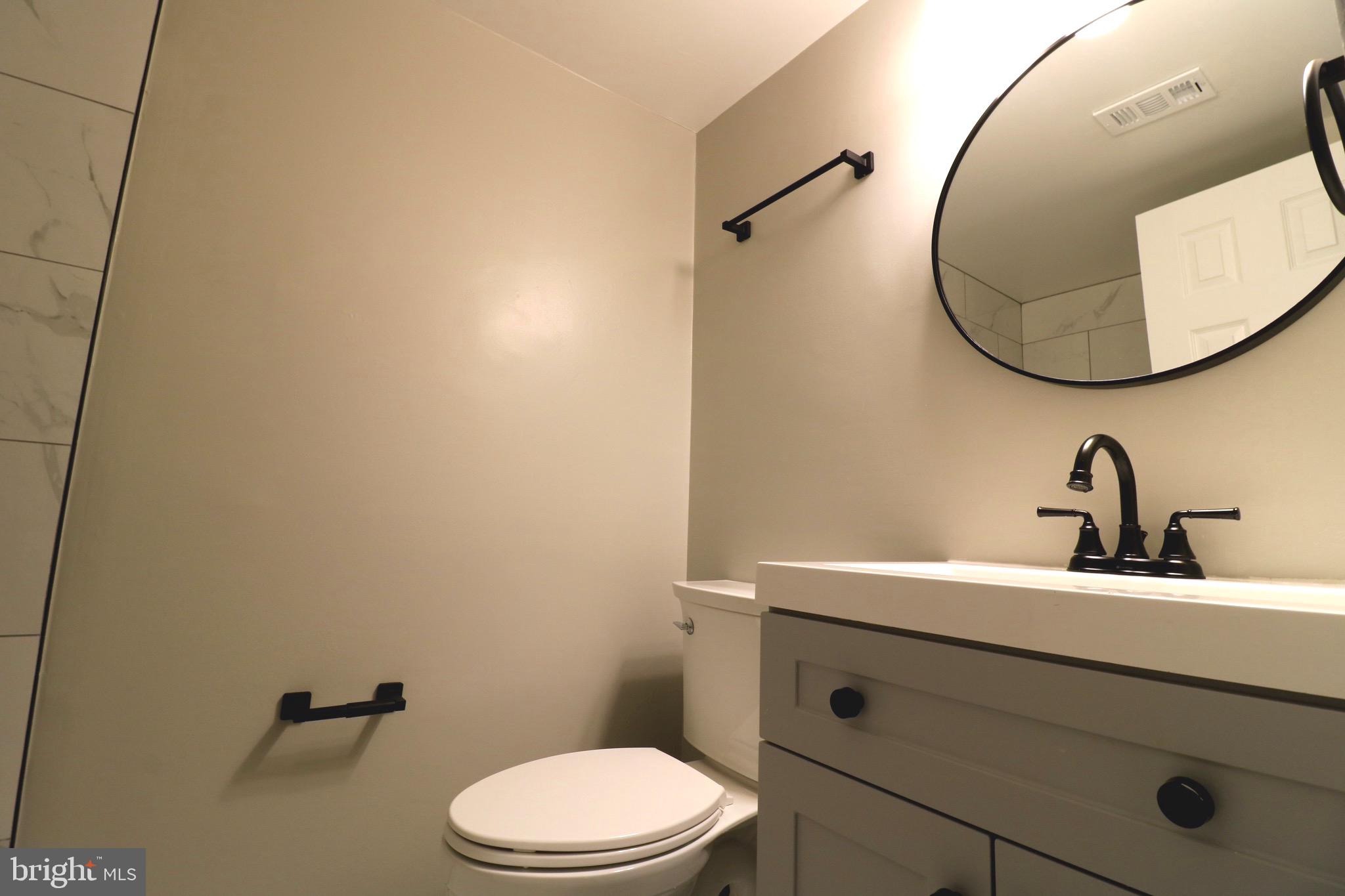 2249 Castle Rock Square, Unit 11C Reston, VA 20191 - Photo 20 of 26 a bathroom with a sink mirror vanity and toilet