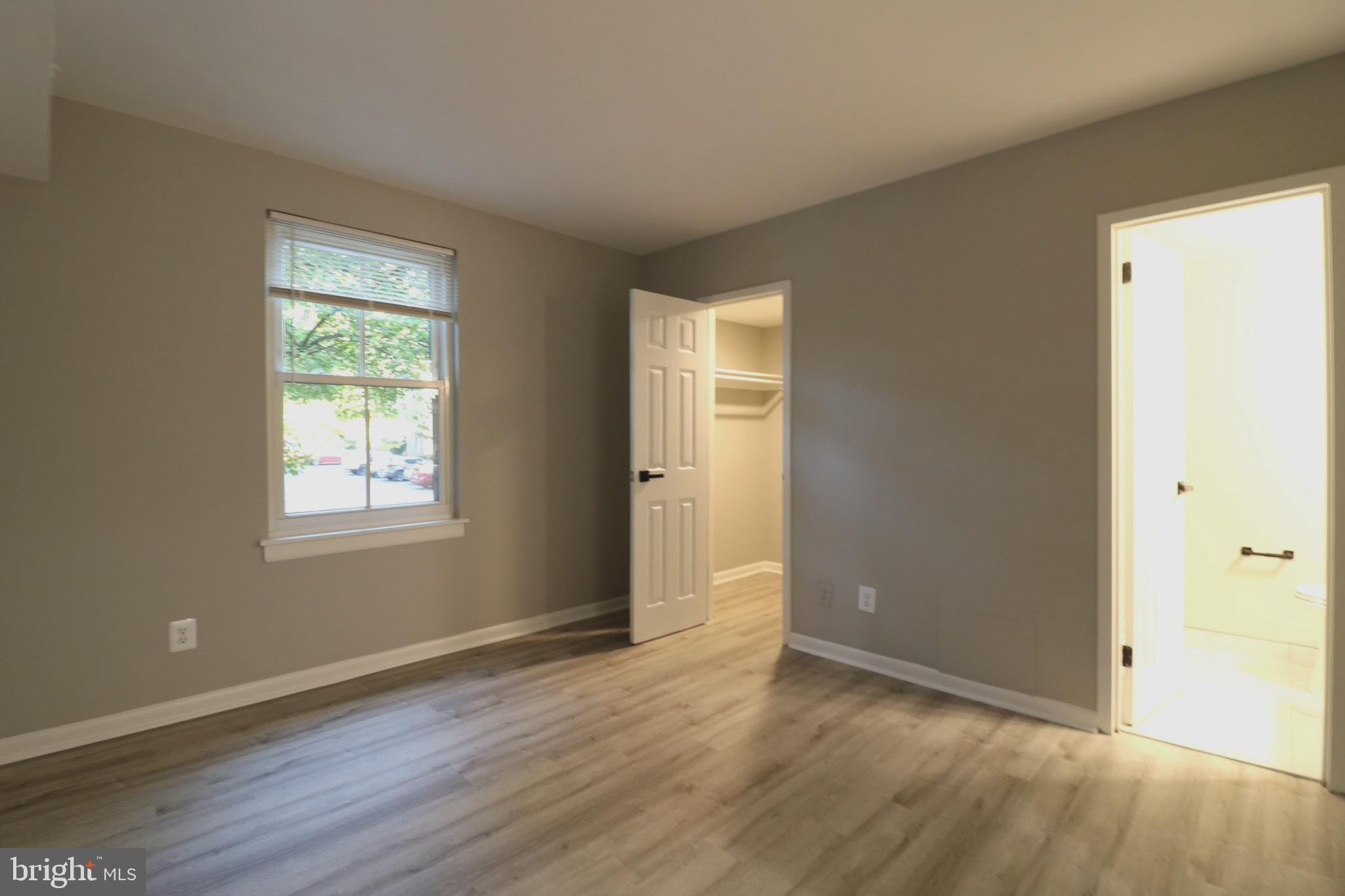 2249 Castle Rock Square, Unit 11C Reston, VA 20191 - Photo 22 of 26 an empty room with wooden floor and windows