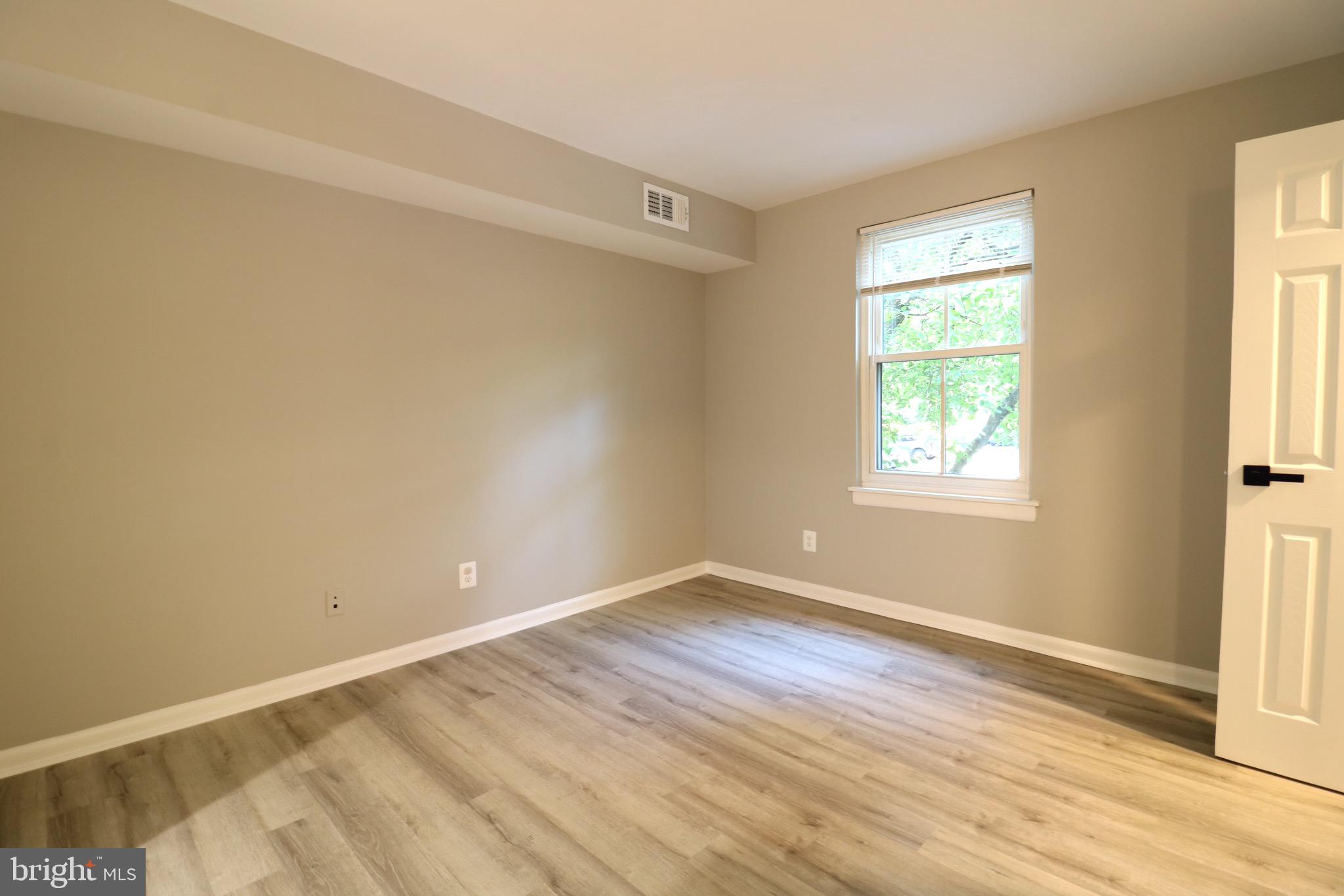 2249 Castle Rock Square, Unit 11C Reston, VA 20191 - Photo 23 of 26 an empty room with wooden floor and windows