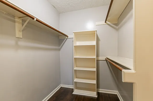 a view of walk in closet with empty racks