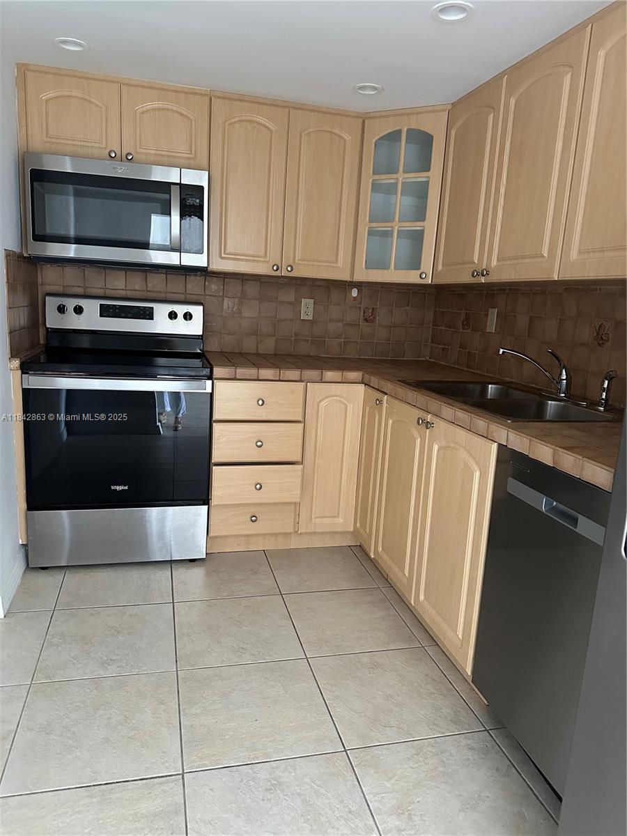 a kitchen with cabinets and steel appliances