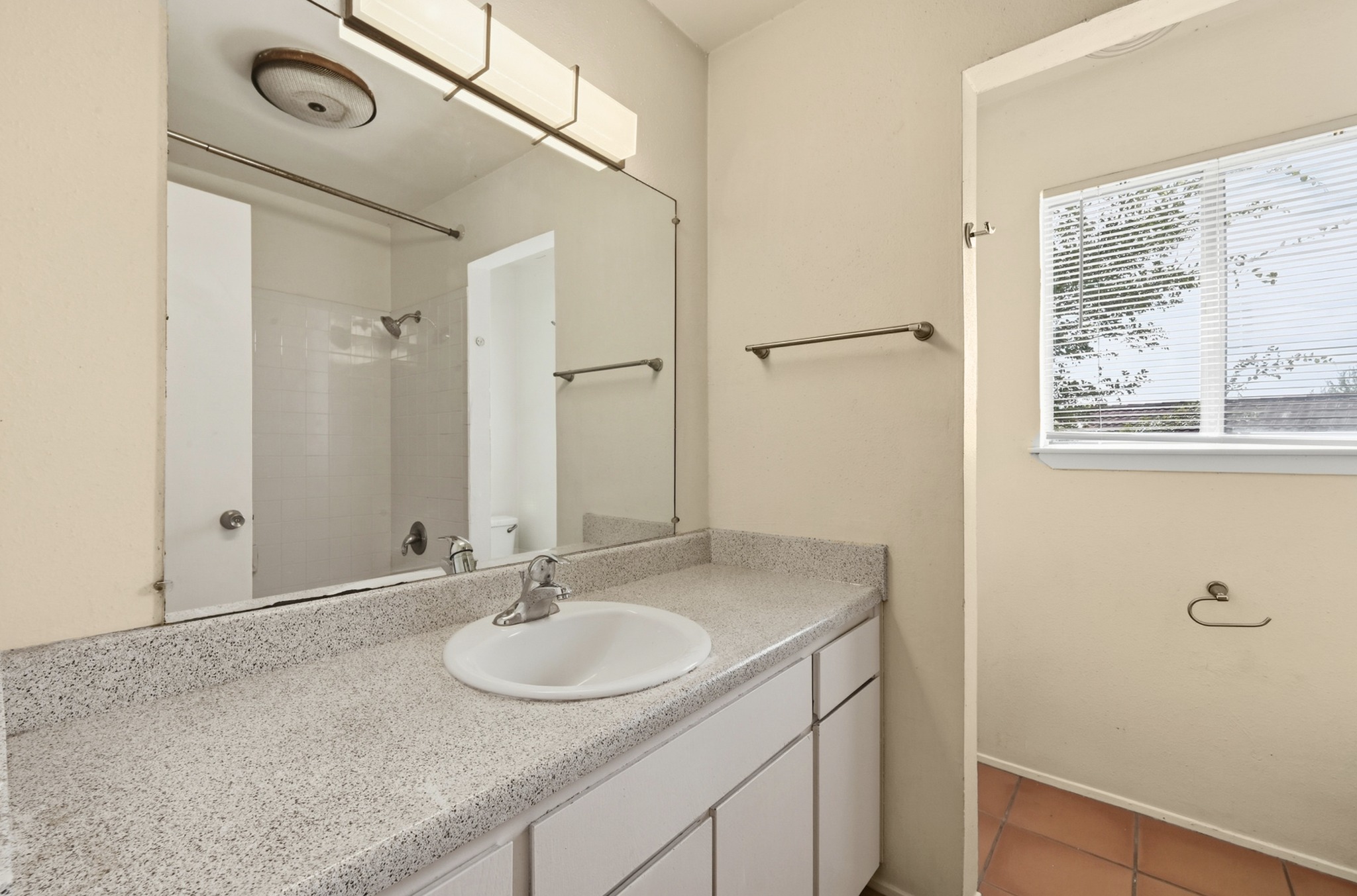 807 Castle Ridge Road, Unit C Austin, TX 78746 - Photo 20 of 26 Natural light streams through the window in this tidy bathroom featuring stone-look counters.