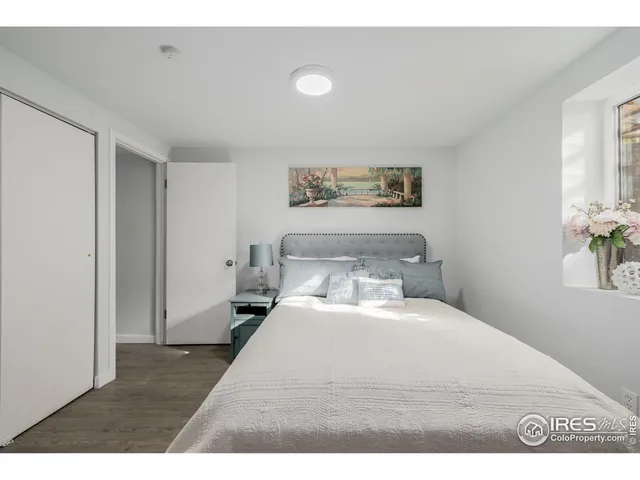 a bedroom with a bed and painting on the wall