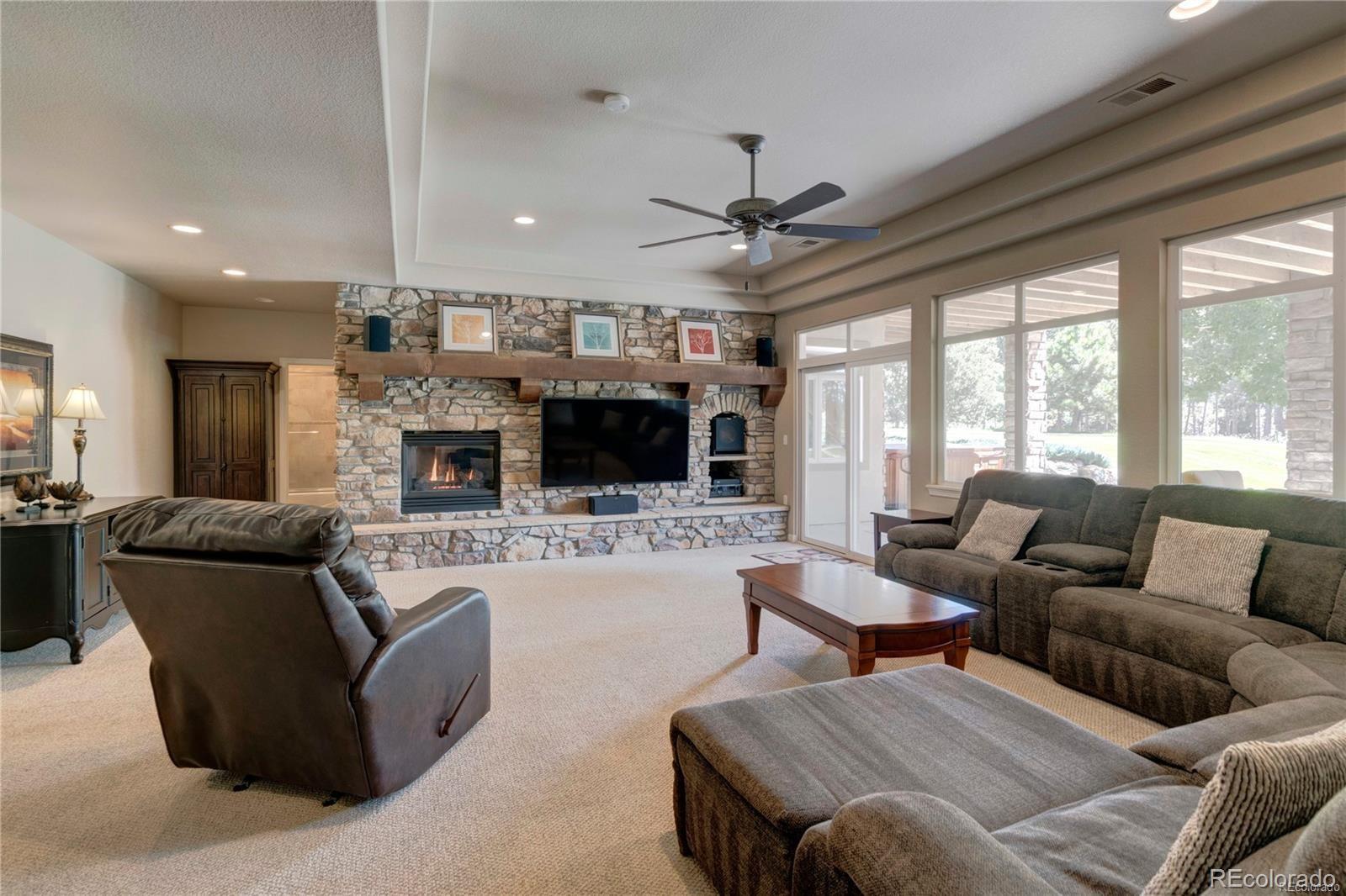 5283 Pinyon Jay Road Parker, CO 80134 - Photo 8 of 12 a living room with furniture a flat screen tv and a fireplace