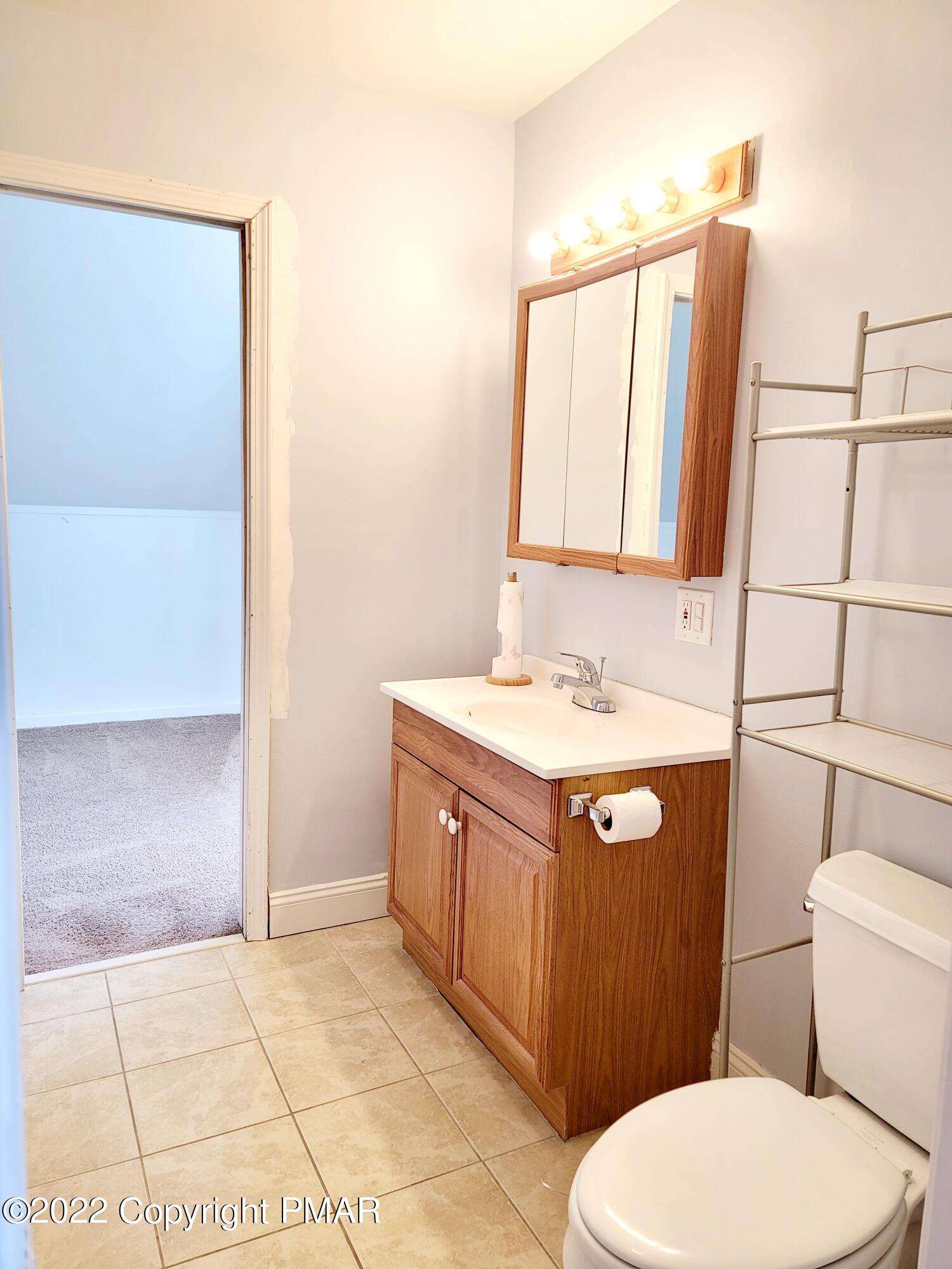 132 Rodeo Drive Hawley, PA 18428 - Photo 19 of 26 a bathroom with a granite countertop toilet sink and mirror