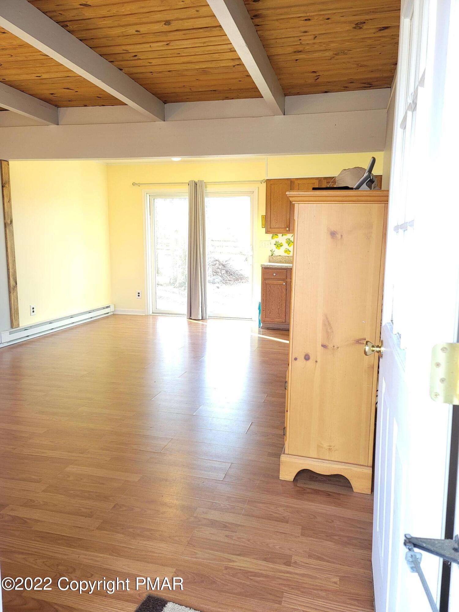 132 Rodeo Drive Hawley, PA 18428 - Photo 3 of 26 a view of an empty room with wooden floor and a window