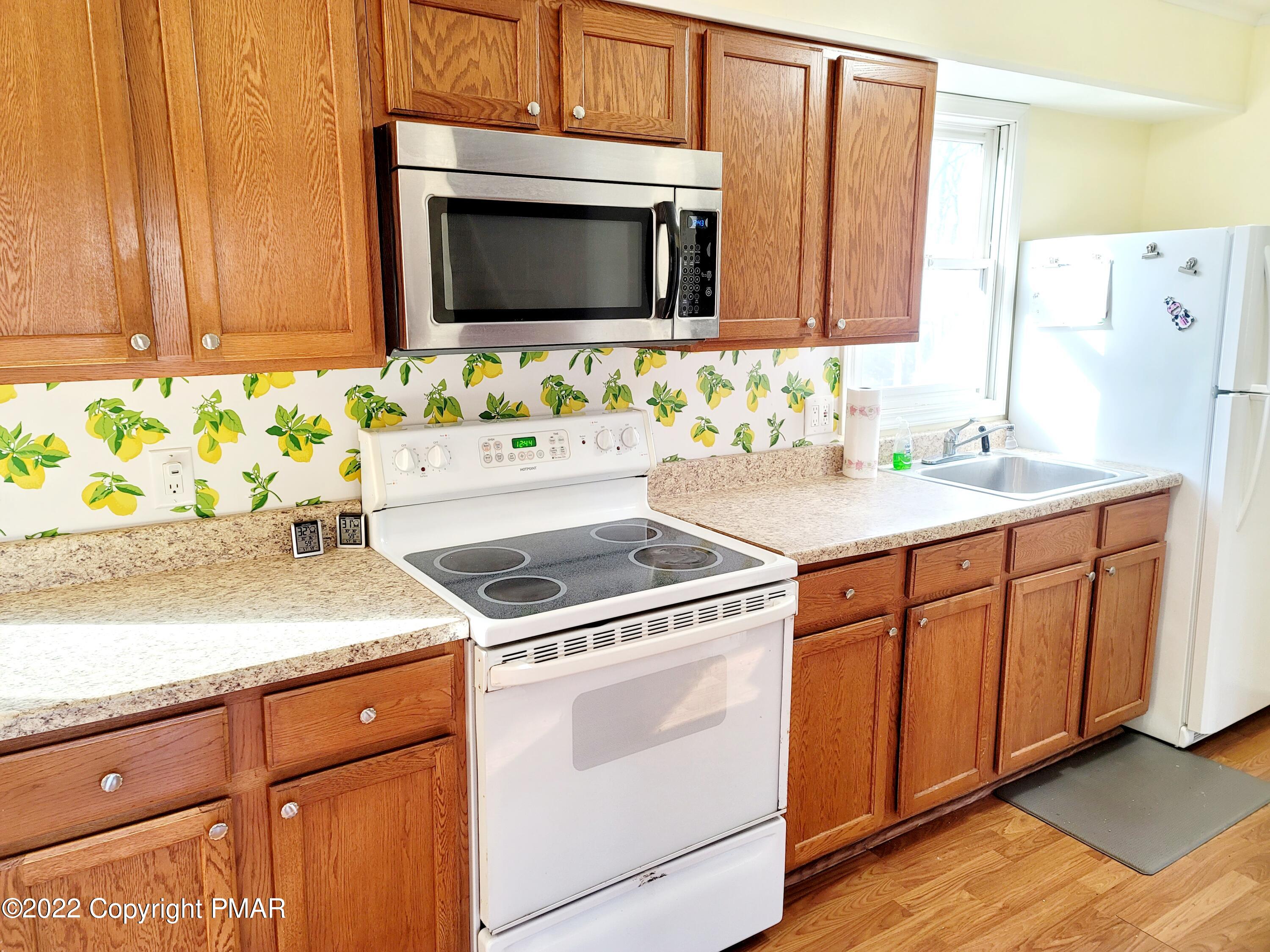 132 Rodeo Drive Hawley, PA 18428 - Photo 6 of 26 a kitchen with granite countertop cabinets stainless steel appliances and wooden floor