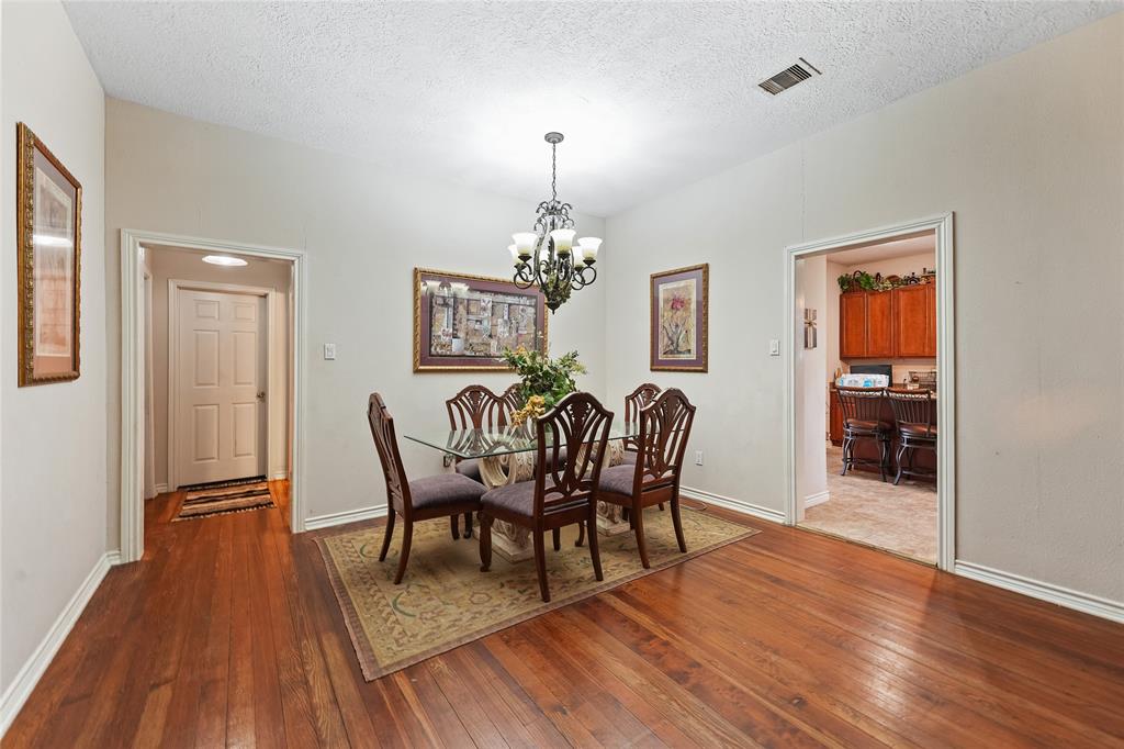 8515 Sandy Hill Road Brenham, TX 77833 - Photo 14 of 25 Dining space featuring dark wood-style floors, a textured ceiling, and a chandelier