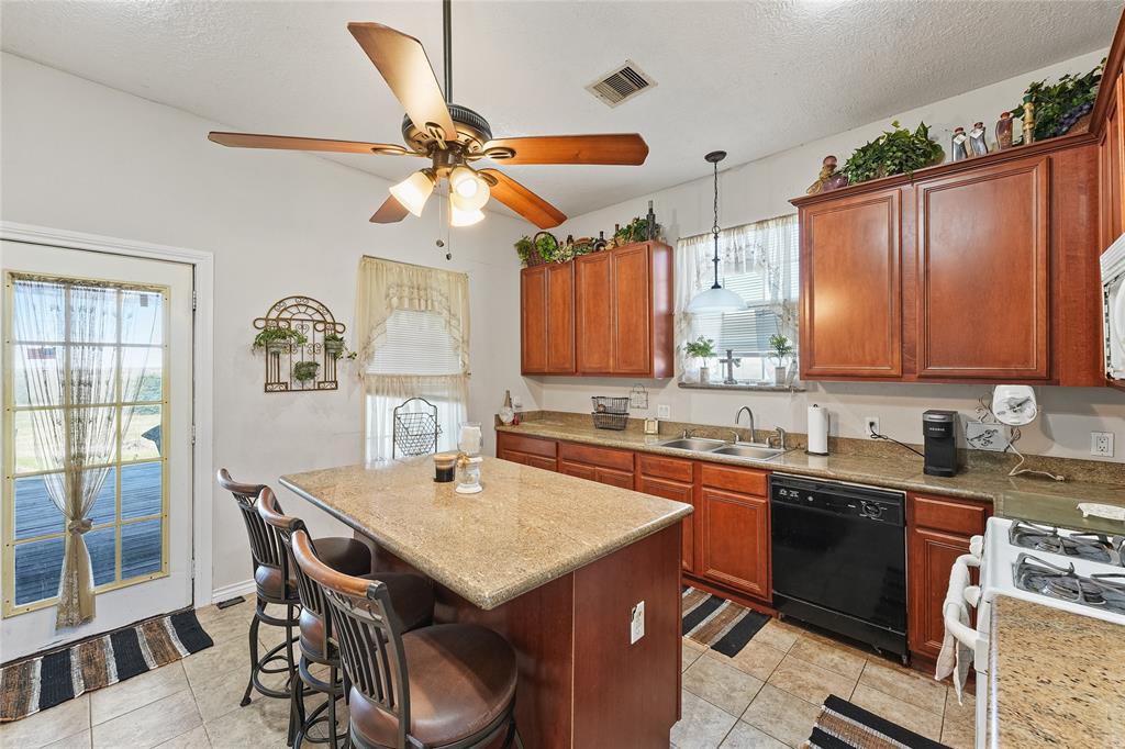 8515 Sandy Hill Road Brenham, TX 77833 - Photo 19 of 25 Kitchen featuring a center island, pendant lighting, dishwasher, white gas range, and light tile patterned floors