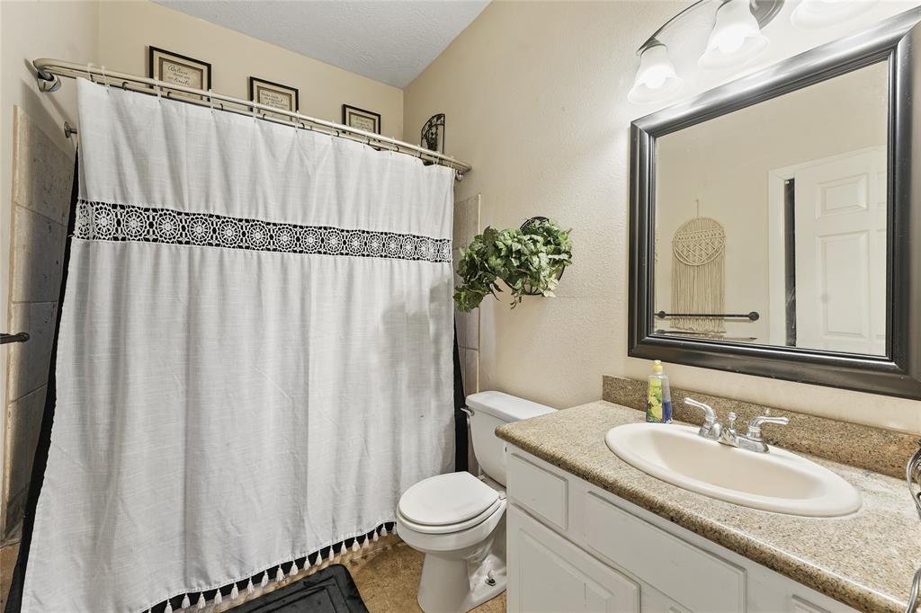 8515 Sandy Hill Road Brenham, TX 77833 - Photo 20 of 25 Bathroom featuring vanity and a shower with shower curtain