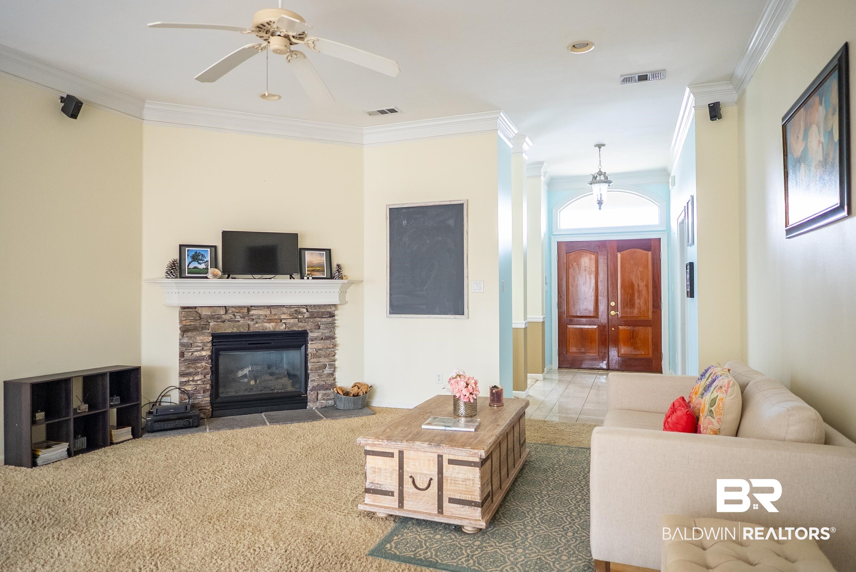 10023 Springfield Court Mobile, AL 36695 - Photo 6 of 50 Living area featuring ornamental molding, a stone fireplace, tile patterned flooring, and ceiling fan