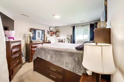 a bedroom with a bed a flat screen tv and dresser