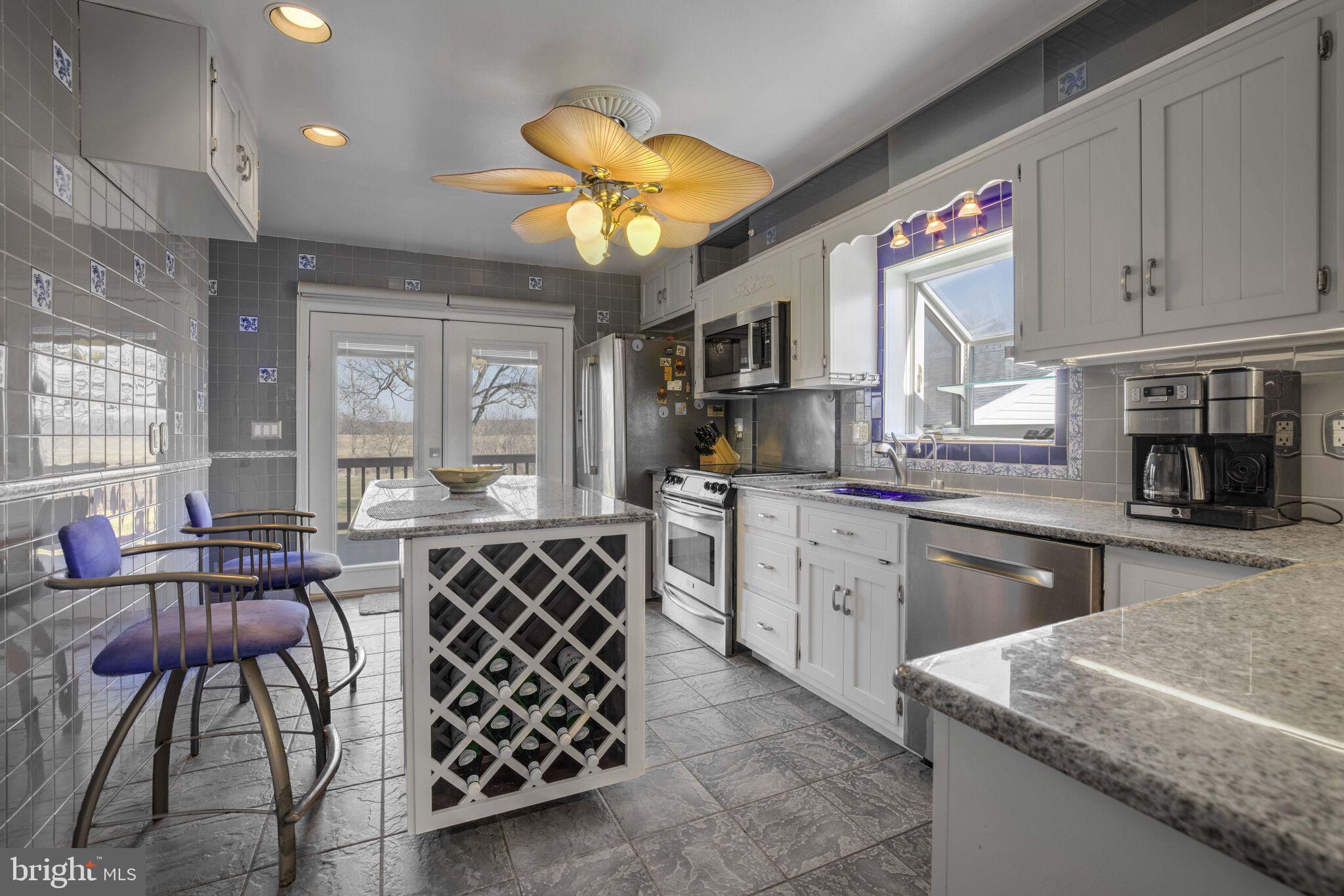 20601 Whites Ferry Road Poolesville, MD 20837 - Photo 9 of 25 a kitchen with stainless steel appliances granite countertop a sink a stove and cabinets
