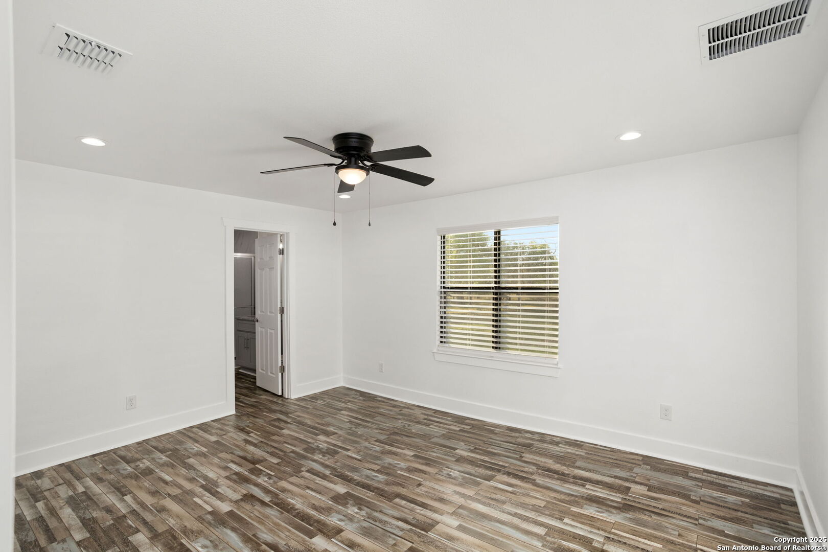 310 Creek Lane Poth, TX 78147 - Photo 27 of 32 a view of an empty room with a window and wooden floor