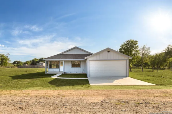 a front view of a house with a yard and a garage
