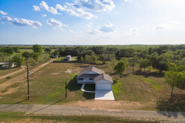a living room with furniture large window and wooden floor