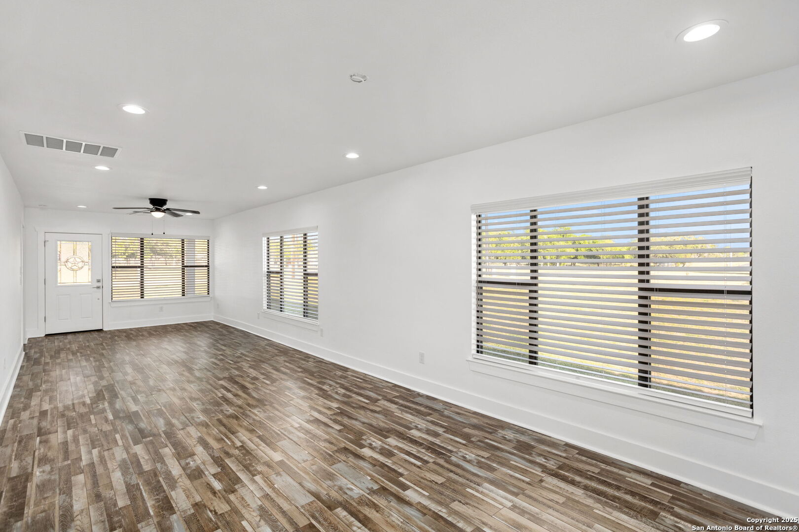 310 Creek Lane Poth, TX 78147 - Photo 10 of 32 an empty room with wooden floor and windows