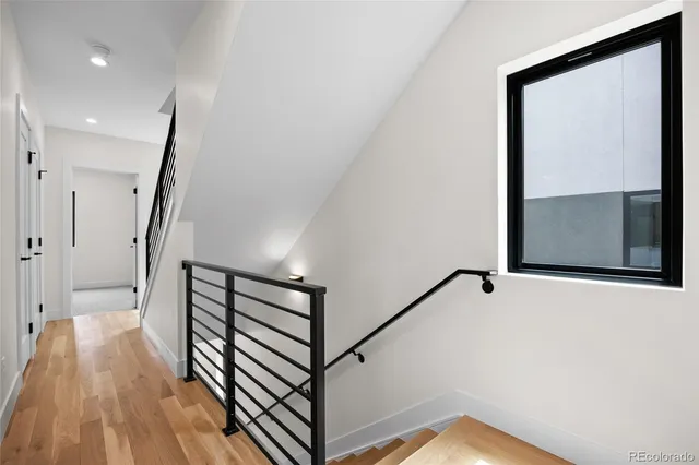 a view of a hallway with wooden floor and staircase