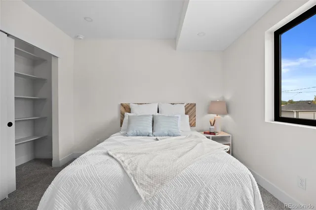 a bedroom with a bed and a large mirror