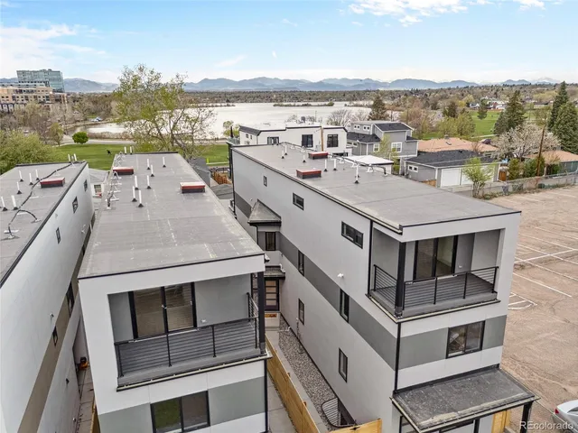 a view of a big house with a big yard and large trees