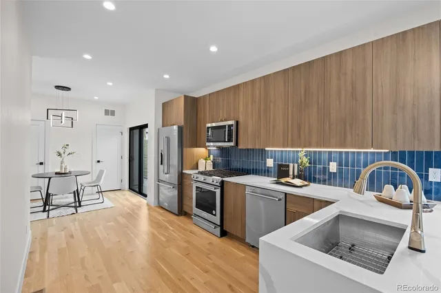 a kitchen with stainless steel appliances a stove a sink a refrigerator and cabinets