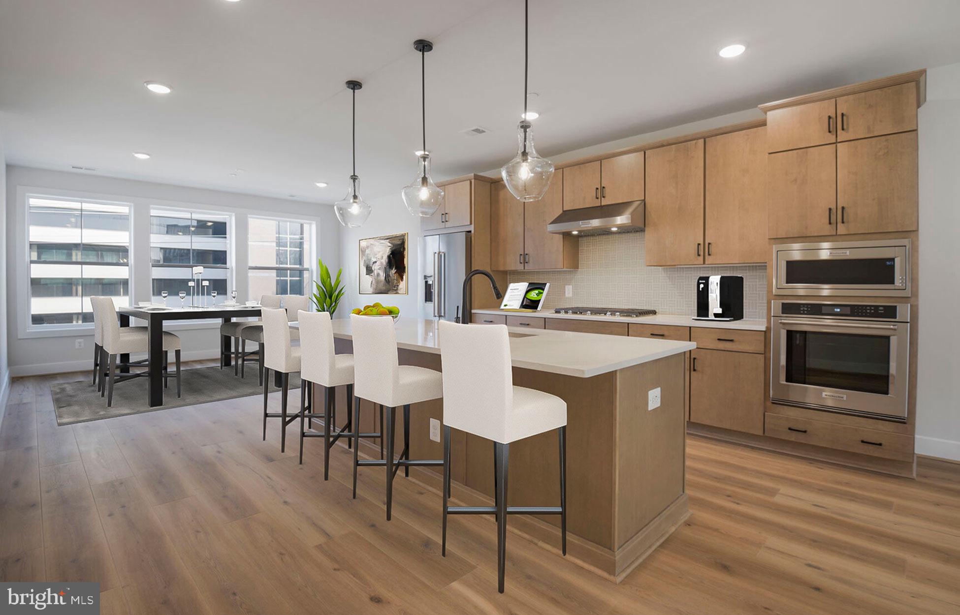 a kitchen with stainless steel appliances kitchen island granite countertop a table chairs and a refrigerator