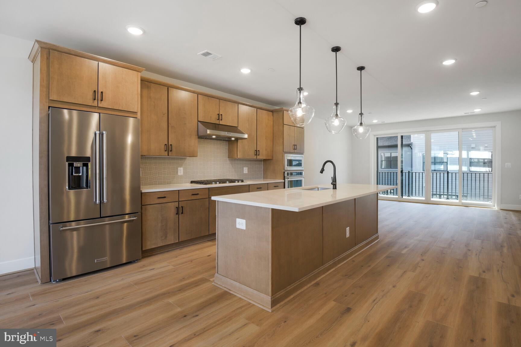 6020 Montrose Road North Bethesda, MD 20852 - Photo 10 of 27 a large kitchen with stainless steel appliances sink a refrigerator and wooden floor
