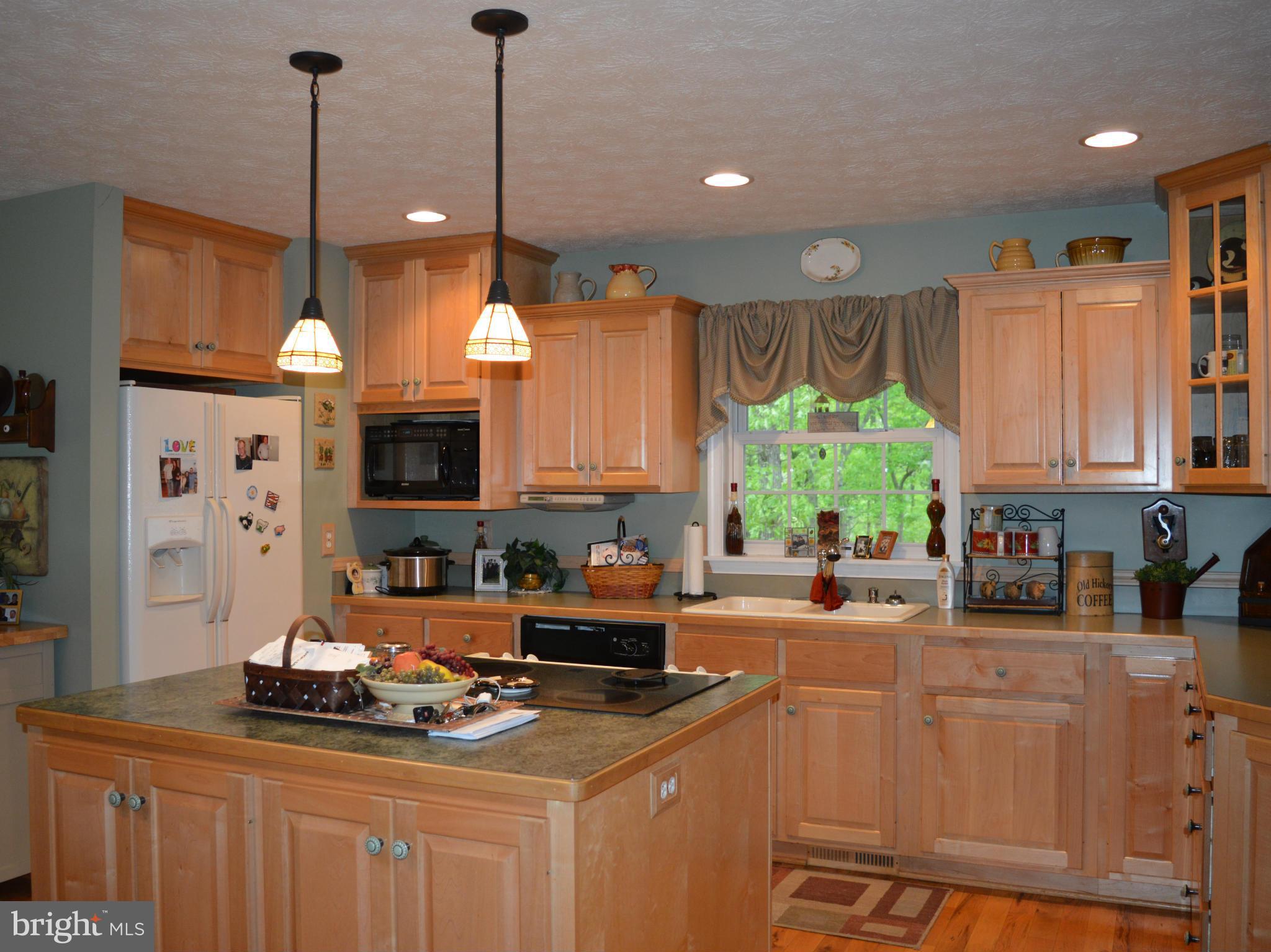 495 McCubbin Road Winchester, VA 22603 - Photo 2 of 29 a kitchen with kitchen island granite countertop a sink a counter top space appliances and cabinets