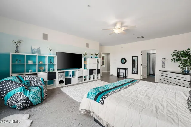 a spacious bedroom with a large bed and a flat screen tv
