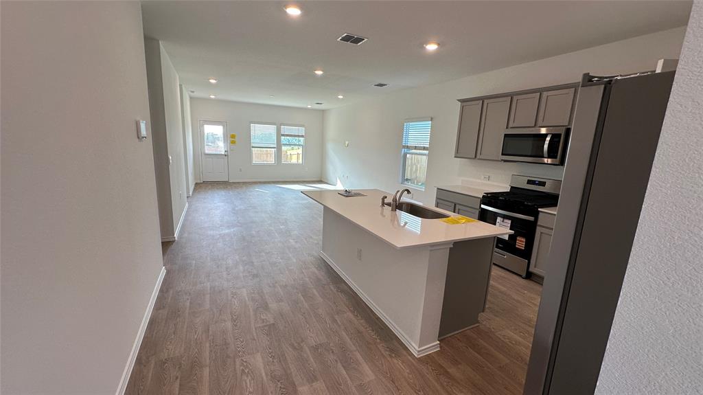 204 Inks Lane Kyle, TX 78640 - Photo 3 of 25 An inviting open-concept layout connects the well-equipped kitchen to a sun-filled living area.