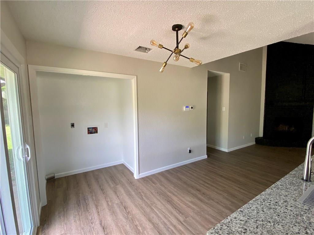 1715 Shadowview Drive, Unit B Austin, TX 78758 - Photo 20 of 28 Hardwood-style flooring extends through this room, with a modern light fixture and sliding glass door.