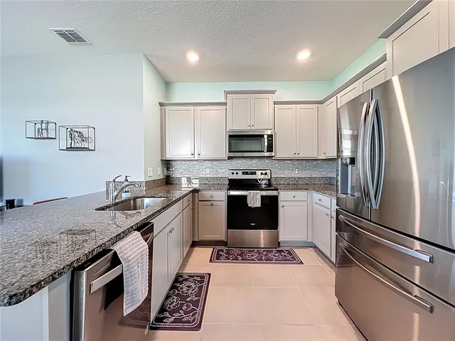 a kitchen with a refrigerator sink and stainless steel appliances