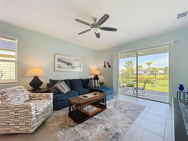 a living room with furniture and a large window with garden view