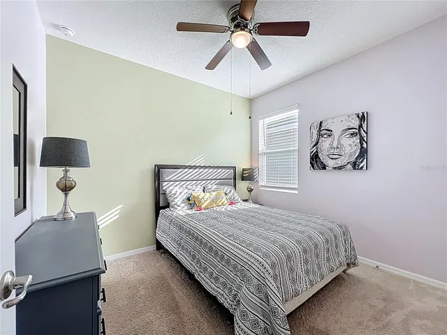 a bedroom with a bed and painting on the wall