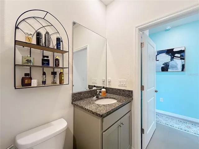 a bathroom with a granite countertop sink and a mirror