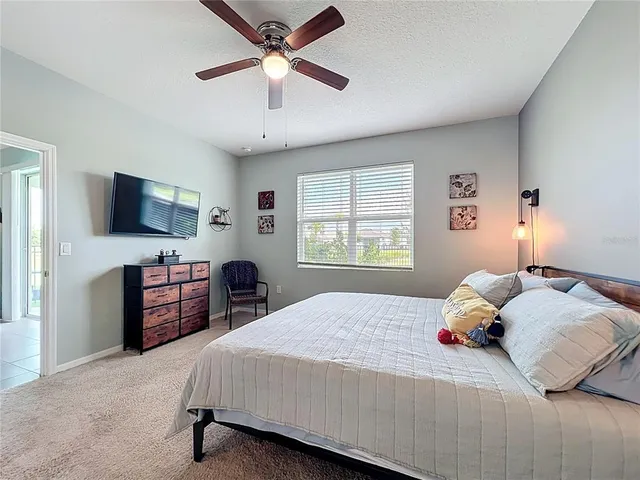 a bedroom with a large bed and a flat tv screen on dresser