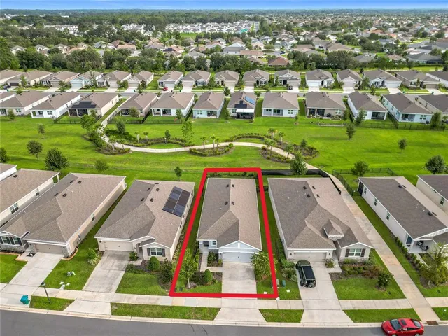 an aerial view of residential houses with outdoor space and parking