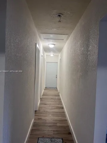 a view of a hallway with wooden floor